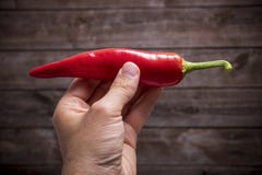 Рука держа накаленный докрасна перец chili стоковая фотография Рука держа накаленный докрасна перец chili стоковая фотография