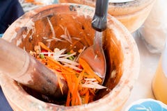 Рука женщины варя пряные зеленые салат, морковь и траву папапайи в деревянном миномете, поставщике еды улицы делает tam сома в Та Стоковая Фотография RF Рука женщины варя пряные зеленые салат, морковь и траву папапайи в деревянном миномете, поставщике еды улицы делает tam сома в Та Стоковая Фотография RF