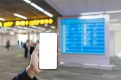 Рука женщины держа модель-макет smartphone и запачканную предпосылку расписания полетов стоковое фото Рука женщины держа модель-макет smartphone и запачканную предпосылку расписания полетов стоковое фото
