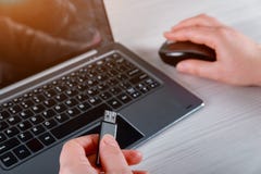 Рука женщины держа прибор USB подключенный с ноутбуком на белой таблице стоковые фото Рука женщины держа прибор USB подключенный с ноутбуком на белой таблице стоковые фото