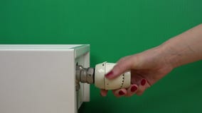 Рука женщины регулируя температуру термостата радиатора на зеленом цвете сток-видео Рука женщины регулируя температуру термостата радиатора на зеленом цвете сток-видео