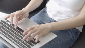 Рука крупного плана независимой женщины работая и печатая на ноутбуке сидя на кресле на живя комнате Рука крупного плана независимой женщины работая и печатая на ноутбуке сидя на кресле на живя комнате
