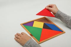 Рука ребенка держа отсутствующую часть в tangram стоковые изображения Рука ребенка держа отсутствующую часть в tangram стоковые изображения
