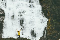 Руки авантюриста женщины счастливые поднятые наслаждаясь большим водопадом стоковое фото rf Руки авантюриста женщины счастливые поднятые наслаждаясь большим водопадом стоковое фото rf