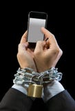 Руки бизнесмена пристрастившийся для работы цепное запертого в наркомании мобильного телефона Стоковые Изображения RF Руки бизнесмена пристрастившийся для работы цепное запертого в наркомании мобильного телефона Стоковые Изображения RF