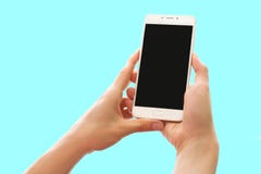 Руки держа смартфон с черным экраном изолированным на пастельной голубой предпосылке стоковые фотографии rf Руки держа смартфон с черным экраном изолированным на пастельной голубой предпосылке стоковые фотографии rf