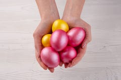 Руки держа современные покрашенные пасхальные яйца r стоковое изображение rf Руки держа современные покрашенные пасхальные яйца r стоковое изображение rf