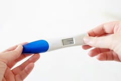 Руки женщины держа положительный цифровой тест на беременность стоковое изображение rf Руки женщины держа положительный цифровой тест на беременность стоковое изображение rf