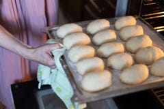 Руки женщины кладя поднос пирогов в печь стоковое изображение rf Руки женщины кладя поднос пирогов в печь стоковое изображение rf