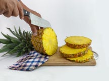 Руки которые отрезали очень вкусный ананас стоковая фотография rf Руки которые отрезали очень вкусный ананас стоковая фотография rf