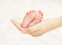 Руки матери ног младенца Newborn Нога ребенк новорожденного, влюбленность семьи Руки матери ног младенца Newborn Нога ребенк новорожденного, влюбленность семьи