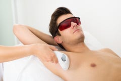 Руки персоны давая терапию лазера Epilation к человеку стоковое фото Руки персоны давая терапию лазера Epilation к человеку стоковое фото