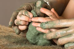 Руки ребенка порции женщины, который нужно работать с сырцовой глиной стоковые изображения rf Руки ребенка порции женщины, который нужно работать с сырцовой глиной стоковые изображения rf