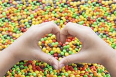 Руки с символом сердца и красочными конфетами стоковое фото Руки с символом сердца и красочными конфетами стоковое фото