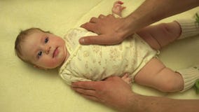 Руки человека массажируя Newborn тело младенца closeup 4K UltraHD, UHD видеоматериал Руки человека массажируя Newborn тело младенца closeup 4K UltraHD, UHD видеоматериал