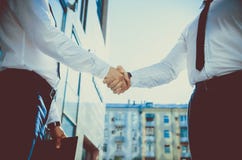 Рукопожатие 2 молодых человеков против buildin офиса мульти-этажа стоковое изображение rf Рукопожатие 2 молодых человеков против buildin офиса мульти-этажа стоковое изображение rf