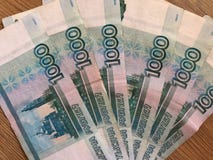 Русские банкноты в деноминациях 1000 рублей на деревянной предпосылке стоковые фотографии rf Русские банкноты в деноминациях 1000 рублей на деревянной предпосылке стоковые фотографии rf