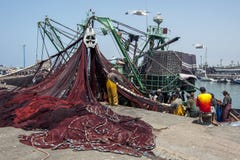 Рыболовы возвращают с их задвижкой к занятой гавани на Essaouira в Марокко стоковое изображение rf Рыболовы возвращают с их задвижкой к занятой гавани на Essaouira в Марокко стоковое изображение rf