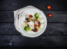 Салат зажаренных овощей с сосисками и краденным яичком стоковые фотографии rf Салат зажаренных овощей с сосисками и краденным яичком стоковые фотографии rf