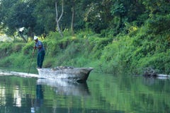 Сафари человека canoeing на деревянных пирогах шлюпки на реке Rapti, в национальном парке Chitwan, Непал стоковые фото Сафари человека canoeing на деревянных пирогах шлюпки на реке Rapti, в национальном парке Chitwan, Непал стоковые фото