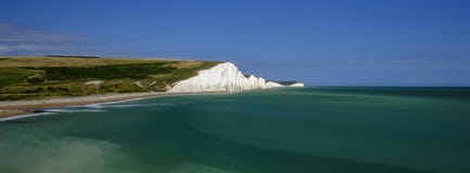 Свет после полудня лета на скалах сестер Severn белых и коттеджах службы береговой охраны на Cuckmere, в южных спусках национальн стоковые фотографии rf Свет после полудня лета на скалах сестер Severn белых и коттеджах службы береговой охраны на Cuckmere, в южных спусках национальн стоковые фотографии rf
