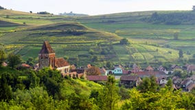 Сельский ландшафт с церковь-крепостью Buzd, Румынией Стоковое Фото Сельский ландшафт с церковь-крепостью Buzd, Румынией Стоковое Фото