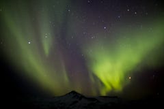 Северное сияние над горой в зиме в Исландии стоковое изображение Северное сияние над горой в зиме в Исландии стоковое изображение
