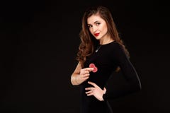 Сексуальное брюнет представляя с обломоками в ее руках, предпосылка вьющиеся волосы черноты концепции покера стоковые изображения Сексуальное брюнет представляя с обломоками в ее руках, предпосылка вьющиеся волосы черноты концепции покера стоковые изображения