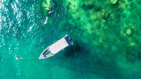 Семья около шлюпки в ясном тропическом море, воздушном взгляде трутня сверху, матери и snorkelers детей плавая в воде стоковое изображение Семья около шлюпки в ясном тропическом море, воздушном взгляде трутня сверху, матери и snorkelers детей плавая в воде стоковое изображение