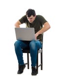 Сердитый парень работая на ноутбуке стоковая фотография rf Сердитый парень работая на ноутбуке стоковая фотография rf