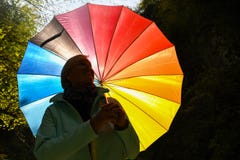 Середина постарела серая с волосами женщина держа красочный зонтик снаружи на солнечный день стоковые фото Середина постарела серая с волосами женщина держа красочный зонтик снаружи на солнечный день стоковые фото