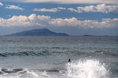 Серфер принимает волну, на surfboard, скольжения вдоль волны, на заднем плане горы, Сорренто Италия стоковые фото Серфер принимает волну, на surfboard, скольжения вдоль волны, на заднем плане горы, Сорренто Италия стоковые фото