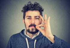 Серьезный человек промелькивая рот держа конфиденциальную информацию Стоковые Фото Серьезный человек промелькивая рот держа конфиденциальную информацию Стоковые Фото