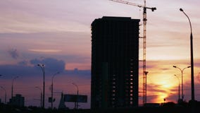 Силуэт строительного проекта против неба захода солнца Ландшафт города с автомобилями и строительной площадкой видеоматериал Силуэт строительного проекта против неба захода солнца Ландшафт города с автомобилями и строительной площадкой видеоматериал
