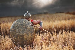 Сильный спартанский ратник в платье сражения с экраном и копьем стоковые фотографии rf Сильный спартанский ратник в платье сражения с экраном и копьем стоковые фотографии rf