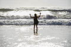 Силуэт молодой счастливой азиатской ослабленной женщины смотрящ одичалое море развевает на пляже захода солнца тропическом стоковая фотография rf Силуэт молодой счастливой азиатской ослабленной женщины смотрящ одичалое море развевает на пляже захода солнца тропическом стоковая фотография rf