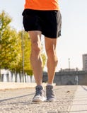 Сильные ноги молодого хода бегуна jogging в улице города на заходе солнца в разминке тренировки города стоковая фотография Сильные ноги молодого хода бегуна jogging в улице города на заходе солнца в разминке тренировки города стоковая фотография