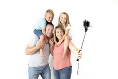 Симпатичные молодые пары принимая автопортрет фото selfie с ручкой и сыном и дочерью нося мобильного телефона на плечах представл Стоковое Изображение RF Симпатичные молодые пары принимая автопортрет фото selfie с ручкой и сыном и дочерью нося мобильного телефона на плечах представл Стоковое Изображение RF