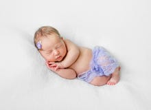 Симпатичный спать newborn с руками под головой в фиолетовых трусах стоковые изображения Симпатичный спать newborn с руками под головой в фиолетовых трусах стоковые изображения