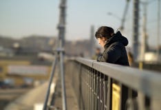 Сиротливая молодая девушка брюнета стоит на мосте на солнечный день стоковая фотография rf Сиротливая молодая девушка брюнета стоит на мосте на солнечный день стоковая фотография rf