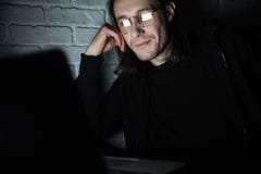 Сконцентрированные стекла человека нося используя портативный компьютер стоковое изображение rf Сконцентрированные стекла человека нося используя портативный компьютер стоковое изображение rf