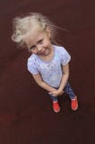 Скромная девушка на красной лужайке стоковое фото Скромная девушка на красной лужайке стоковое фото