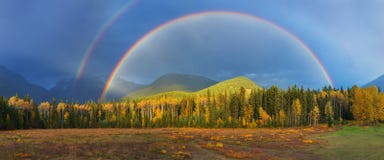 Славная радуга лета над горами Изумлять дождливый и пасмурный день Канадские скалистые горы, Канада стоковое изображение Славная радуга лета над горами Изумлять дождливый и пасмурный день Канадские скалистые горы, Канада стоковое изображение