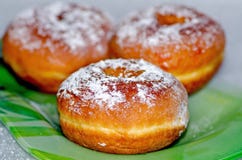 Сладкие вкусные donuts взбрызнутые с ложью напудренного сахара на зеленой стеклянной пластинке, национальном блюде на праздник Ха стоковое фото rf Сладкие вкусные donuts взбрызнутые с ложью напудренного сахара на зеленой стеклянной пластинке, национальном блюде на праздник Ха стоковое фото rf