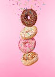 Сладостные donuts летая изолированные на розовой предпосылке Стоковое Изображение Сладостные donuts летая изолированные на розовой предпосылке Стоковое Изображение