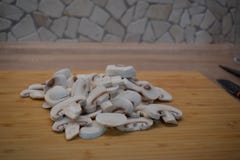 Слезли и отрезанные грибы, подготовленные для еды куриной грудки жареной курицы с грибами и салатом стоковое изображение rf Слезли и отрезанные грибы, подготовленные для еды куриной грудки жареной курицы с грибами и салатом стоковое изображение rf