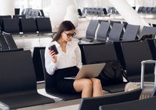 Случайная женщина работая на ноутбуке в зале аэропорта Женщина ждать его полет на крупном аэропорте, сидя на стуле и стоковые фото Случайная женщина работая на ноутбуке в зале аэропорта Женщина ждать его полет на крупном аэропорте, сидя на стуле и стоковые фото