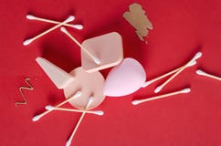Смажьте concealer, губки и ручки уха на красной предпосылке Взгляд сверху инструментов красоты стоковые изображения rf Смажьте concealer, губки и ручки уха на красной предпосылке Взгляд сверху инструментов красоты стоковые изображения rf