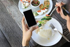Смартфон удерживания бизнесмена и обед иметь в ресторане стоковые изображения rf Смартфон удерживания бизнесмена и обед иметь в ресторане стоковые изображения rf