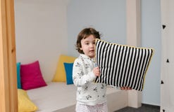 Смешная маленькая девочка в милых pijamas имея потеху стоковые изображения rf Смешная маленькая девочка в милых pijamas имея потеху стоковые изображения rf